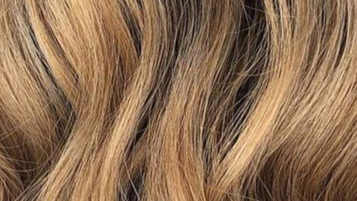 Close-up van balayage in zachte golven, van karamel naar donkerblond