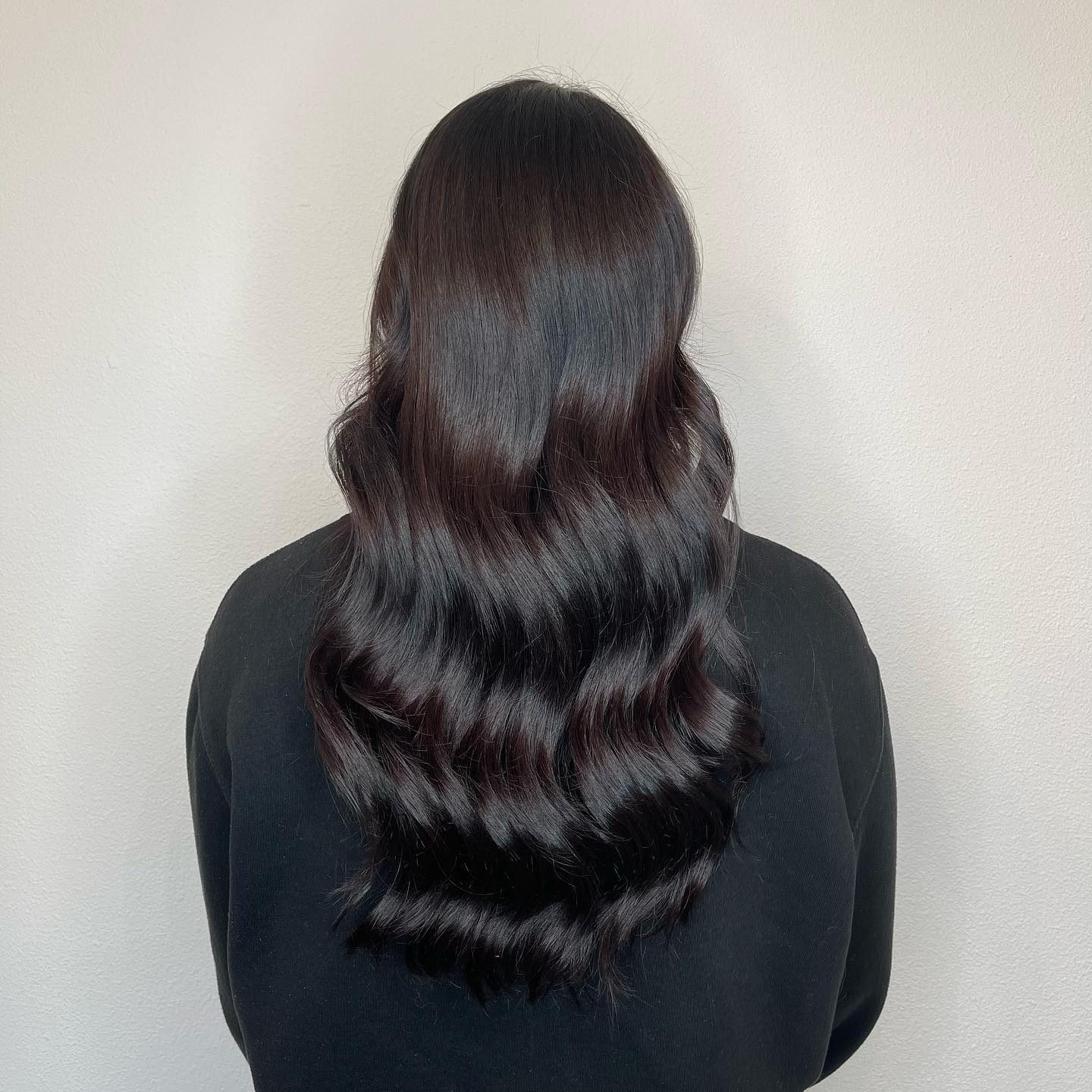 Na: lang donker haar in glanzende golven, van achteren