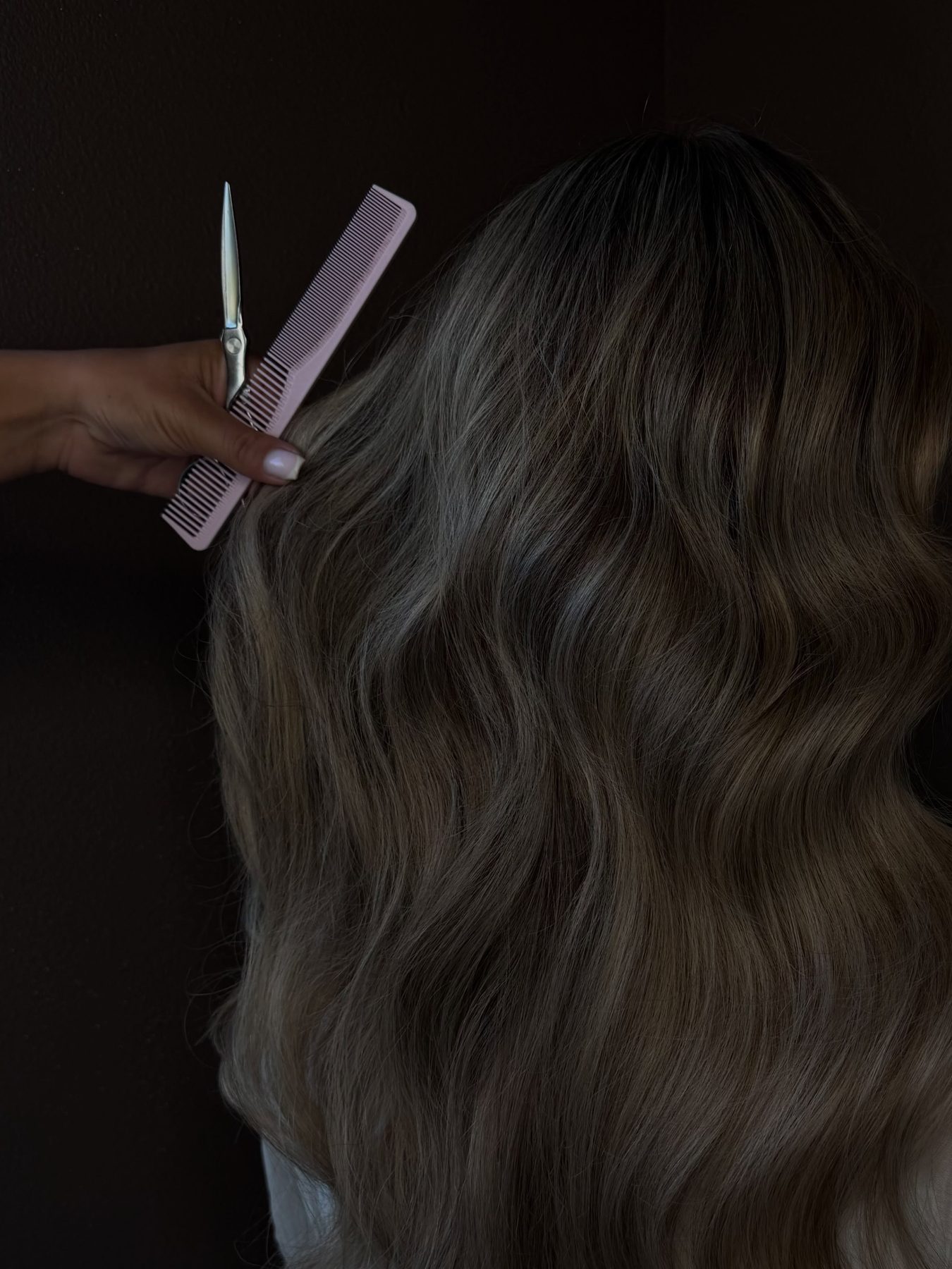 Lang grijsblond haar met golven wordt gekamd en geknipt