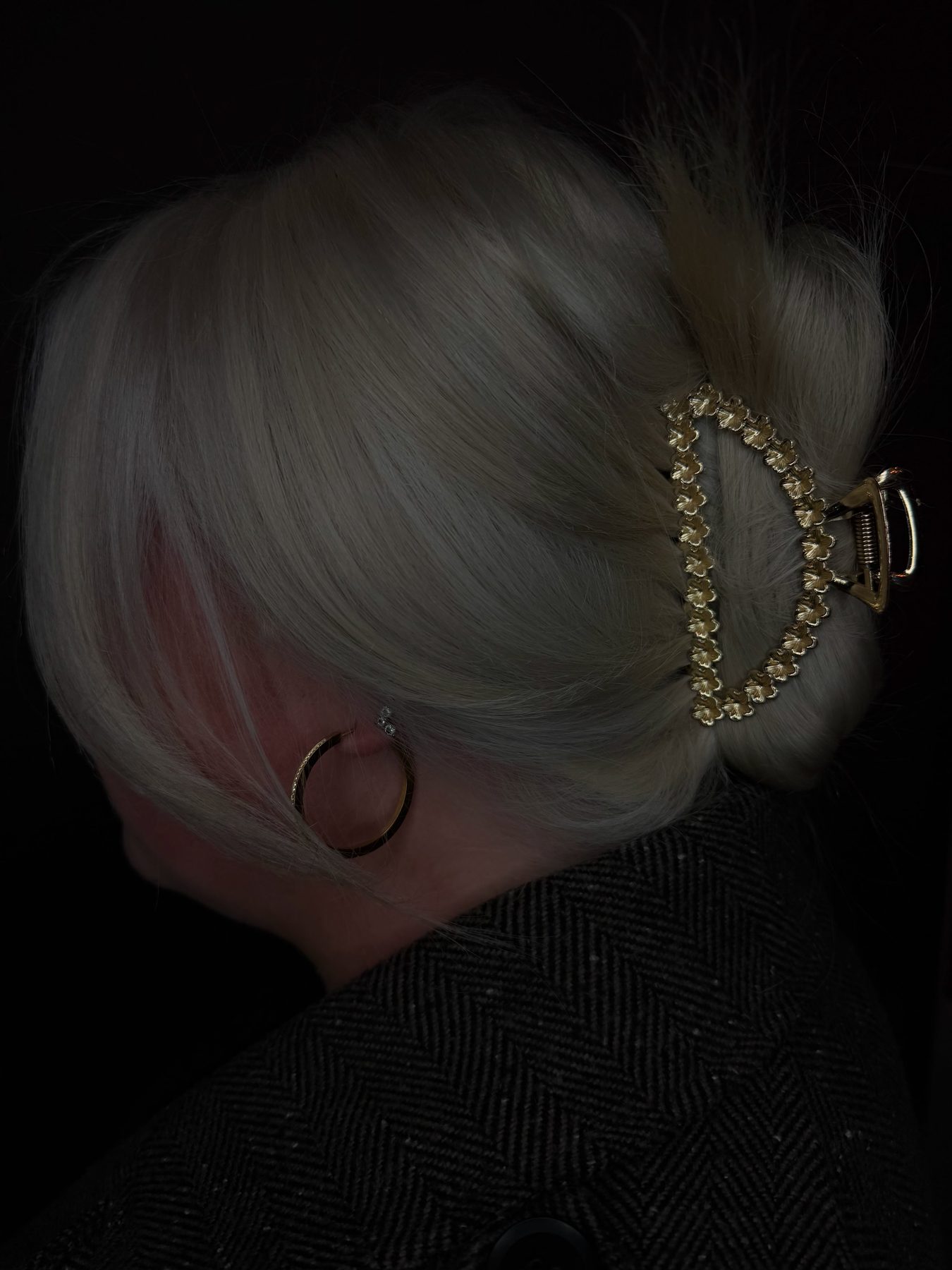 Platinablond haar opgestoken met een gouden klem